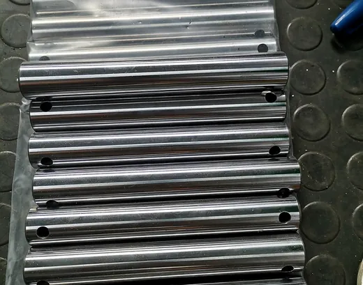 Serie de pasadores de acero pulidos con perforaciones transversales en bolsa plástica