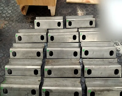 Catorce piezas de plancha plegada con perforaciones oblongas, numeradas una por una