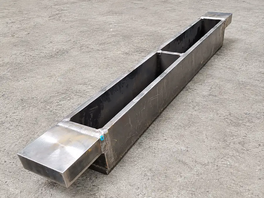 Canaleta larga de plancha de acero soldada con boca rectangular sobre el piso