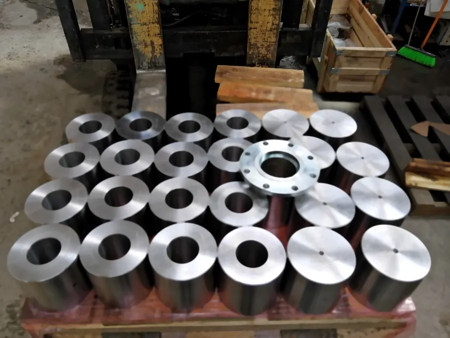 Lote de cilindros de acero torneados y una brida zincada sobre pallet
