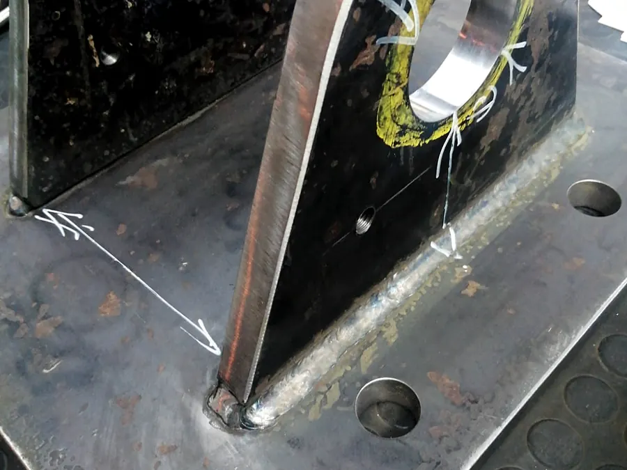 Orejas de plancha gruesa soldadas sobre placa base perforada con marcas de trazado
