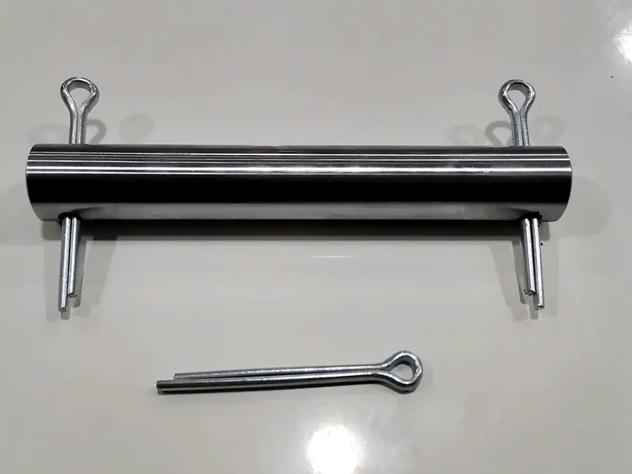 Pasador de acero torneado con chavetas zincadas en ambos extremos sobre fondo blanco