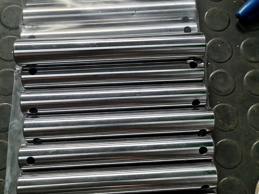Serie de pasadores de acero pulidos con perforaciones transversales en bolsa plástica
