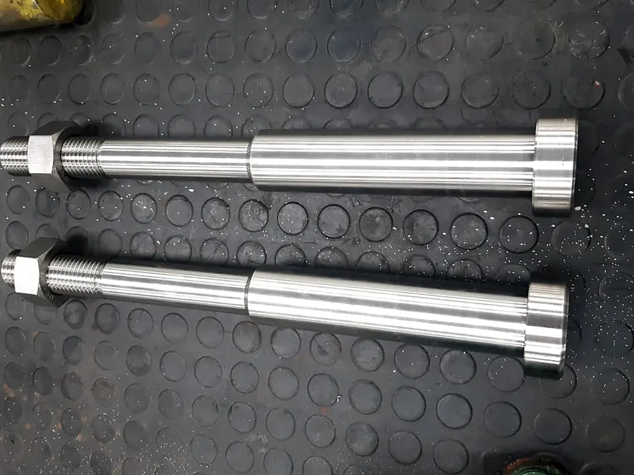 Dos pernos largos torneados con cabeza de disco, rosca y tuerca hexagonal