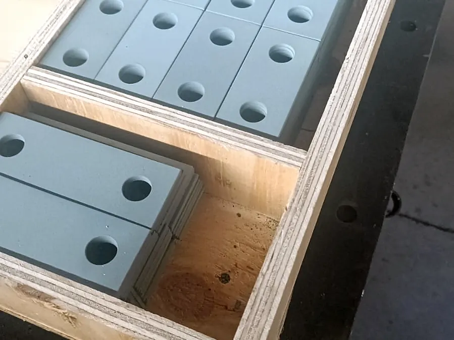 Platinas de acero pintadas con dos perforaciones embaladas en cajón de madera terciada