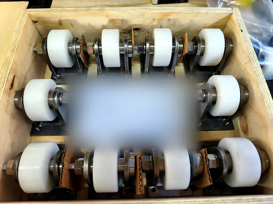 Cajón de madera con diez ruedas blancas montadas en soportes soldados